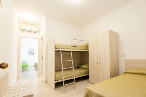 a small bedroom with bunk beds and a ladder at Hotel Sfinalicchio in Vieste
