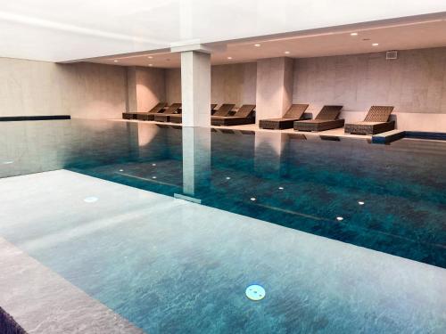 a swimming pool with chairs in a building at Samosia in Karpacz