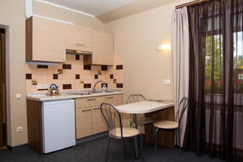 Una cocina con una mesa y sillas y un fregadero. en Yuzhniy Dvorik, en Odessa
