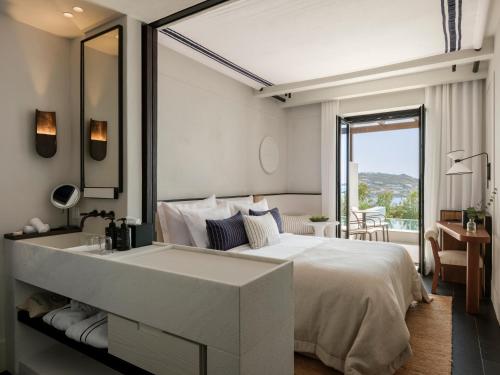 a bedroom with a large white bed and a sink at Anandes Hotel in Mýkonos City