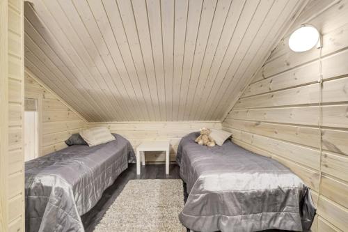 a bedroom with two beds and a dog laying between them at Skicamp 3 in Pyhätunturi