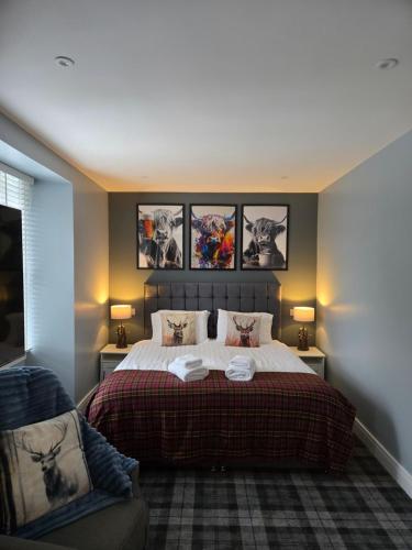 Un dormitorio con una cama con tres cuadros en la pared. en Ben Lomond Apartment, en Tarbet