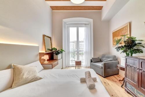 a bedroom with a bed and a couch and a chair at Castillo 31 by Clabao in Pamplona