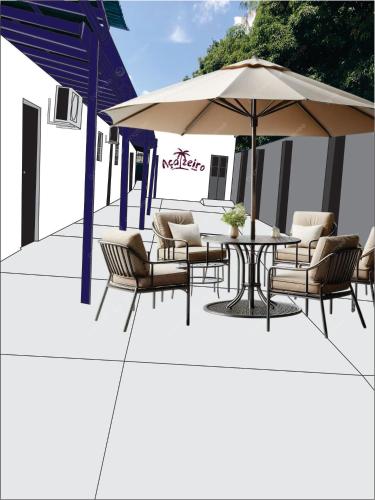 Un patio con una mesa y sillas y una sombrilla. en Açaizeiro Hostel, en Belém