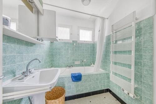 une salle de bain avec un lavabo et une baignoire dans l'établissement Maison Escapade au Lac, à Lacanau