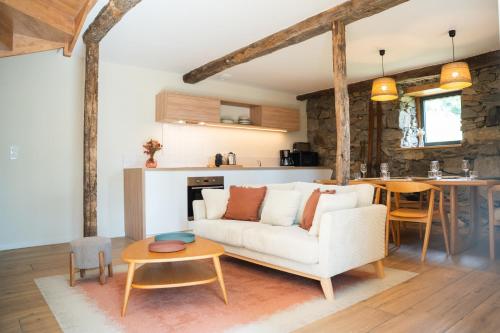 a living room with a white couch and a table at Les Granges du Hautacam in Artalens-Souin