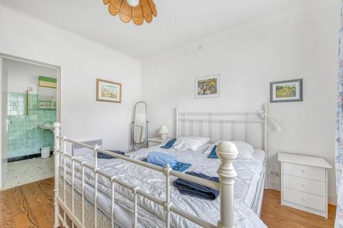 une chambre avec un lit blanc et un miroir dans l'établissement Maison Escapade au Lac, à Lacanau