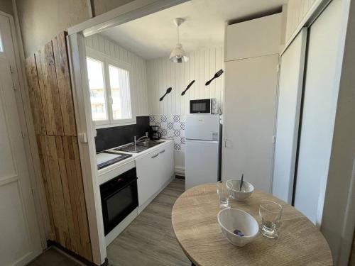 - une petite cuisine avec une table et un comptoir dans l'établissement Appartement T2 Cabine à 50m de la Plage, Tout Confort, Proche Commerces et Animations ! - FR-1-324A-1, à Saint-Jean-de-Monts