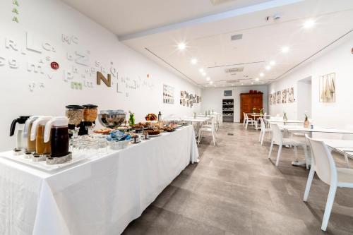 a restaurant with white tables and white chairs at Albergo La Rocca in Brisighella