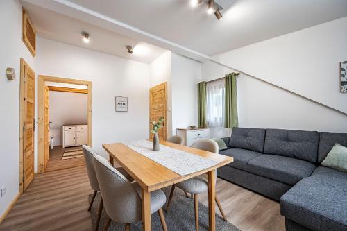 a living room with a table and a couch at Chaty Snowflakes v Snowpark Lučivná in Lučivná