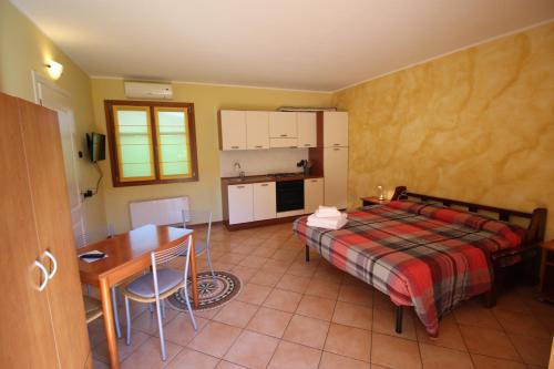 a bedroom with a bed and a table and a kitchen at Ai Casali in Cividale del Friuli