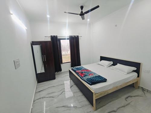 a bedroom with a bed and a ceiling fan at Stay For Couples Near IIM College in Lucknow
