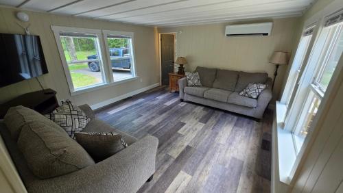 a living room with two couches and a flat screen tv at Abbot Trailside Lodging in Abbot Village