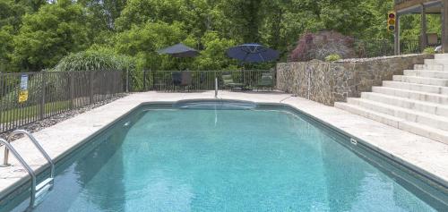 a swimming pool with an umbrella in a yard at Shirley's Bed and Breakfast in Roanoke