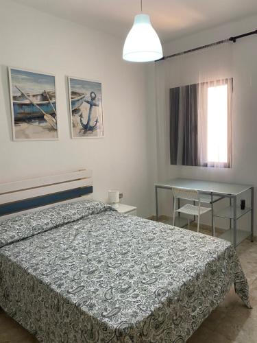 a bedroom with a bed and a table and a window at Estocolmo Lovely in Gran Tarajal
