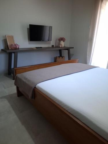a bedroom with a bed with a tv on the wall at Titi's home in Ofrínion