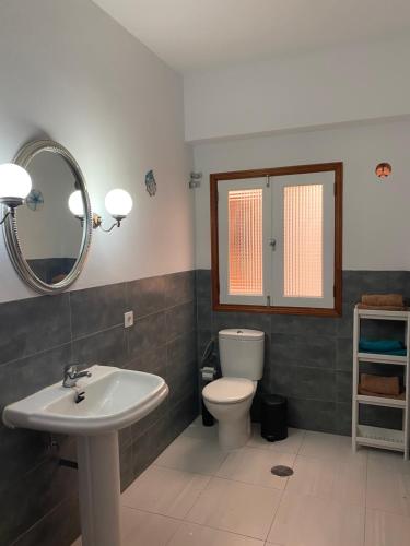 a bathroom with a sink and a toilet and a mirror at Estocolmo Lovely in Gran Tarajal