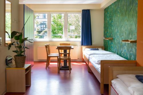 a room with two beds and a table and chairs at Schanzenstern Altona GmbH in Hamburg