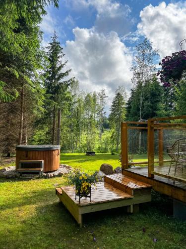 Una terraza de madera con jacuzzi en un patio. en ARKA Puhkemajad, en Päidre