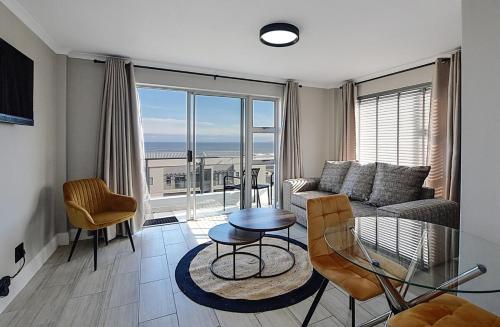 a living room with a couch and a glass table at Mountain and Oceanview at Blouberg in Cape Town