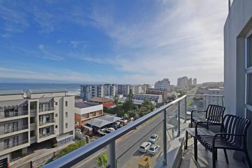 a balcony with two chairs and a view of a city at Mountain and Oceanview at Blouberg in Cape Town