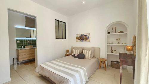 - une chambre blanche avec un lit et un lavabo dans l'établissement Casa Andréa Agreable T3 avec grand jardin à 3mn de la plage, à Sanary-sur-Mer