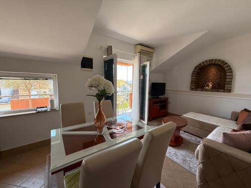 a living room with a glass table and chairs at Grand Apartments Scepanovic in Tivat