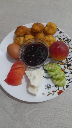 a plate of food with fruit and other foods on it at Aila Apartament in Gjirokastër