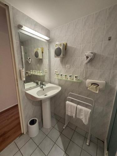 a bathroom with a sink and a mirror at Les Apparts du Valois, Cognac Centre in Cognac