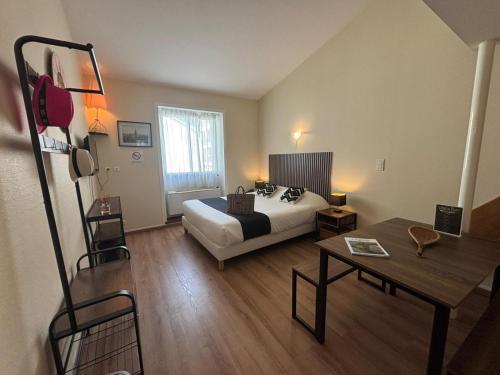 a bedroom with a bed and a table in a room at Les Apparts du Valois, Cognac Centre in Cognac