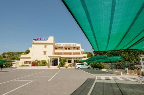 a building with a white car parked in a parking lot at Hotel Sfinalicchio in Vieste