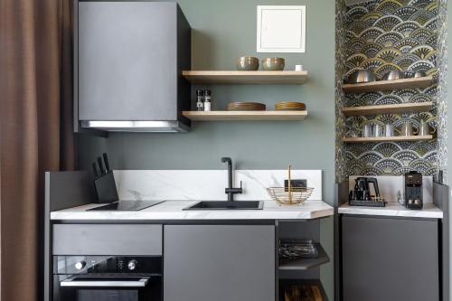 a kitchen with a sink and a stove at Shanghai Hotel Holland in Delft