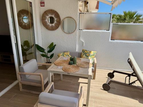 eine Terrasse mit Tisch und Stühlen auf einer Veranda in der Unterkunft Casa Oceanico Los Gigantes in Acantilado de los Gigantes