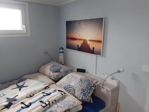 una camera da letto con un letto e un quadro sul muro di Hausboot-schwimmendes-Ferienhaus-im-Havelbogen-Haus-auf-dem-Wasser a Kützkow