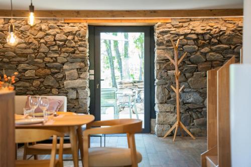 a dining room with a stone wall at Les Granges du Hautacam in Artalens-Souin