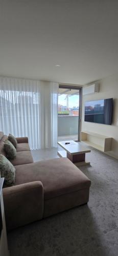 a living room with a couch and a large window at Soldouro Aveiro Station in Aveiro