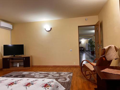 a living room with a tv and a chair and a table at Vila Ovi Salin in Turda