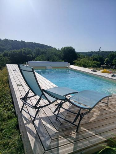 une chaise assise sur une terrasse à côté d'une piscine dans l'établissement Joli studio au calme, à Crégandie