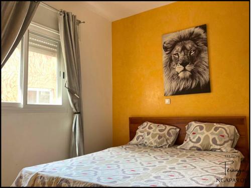 a bedroom with a picture of a lion on the wall at Maison Téranga Ngaparou in Ngaparou