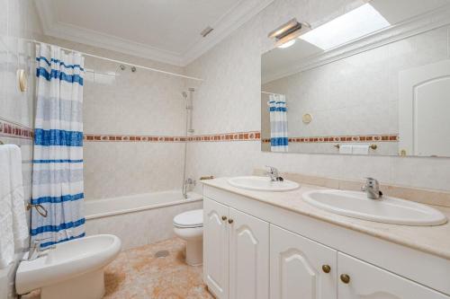 ein Badezimmer mit zwei Waschbecken und einer Toilette und einem Spiegel in der Unterkunft Tantulia bungalow El Conde 2 rooms in Adeje