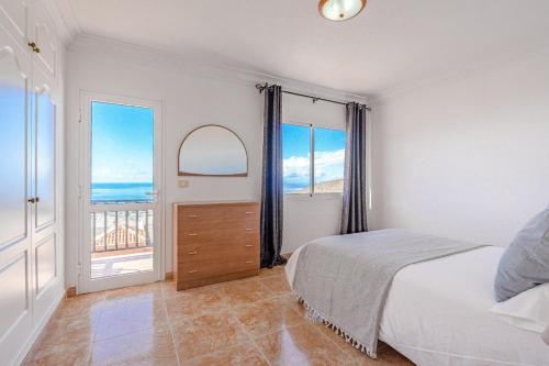 ein Schlafzimmer mit einem Bett und einem großen Fenster in der Unterkunft Tantulia bungalow El Conde 2 rooms in Adeje