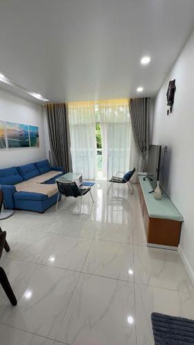 Una sala de estar con un sofá azul y una mesa. en Căn Hộ 2 PN Ocean-vista, en Ấp Phú Tịnh (2)