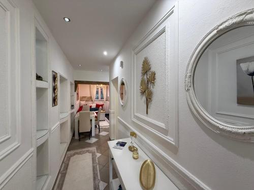 a white hallway with a mirror on the wall at Grand Apartments Scepanovic in Tivat