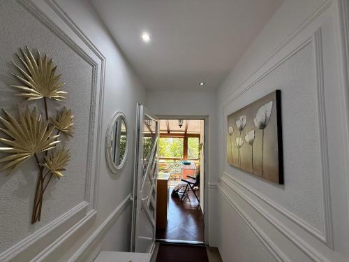 a hallway with white walls and a staircase with a plant at Grand Apartments Scepanovic in Tivat