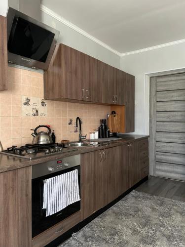 a kitchen with wooden cabinets and a stove and a sink at Роздоріжжя in Yaremche