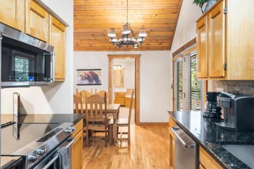 a kitchen with wooden cabinets and a dining room at Baldknobber Ridge Escape - West Branson Cabin in Branson West