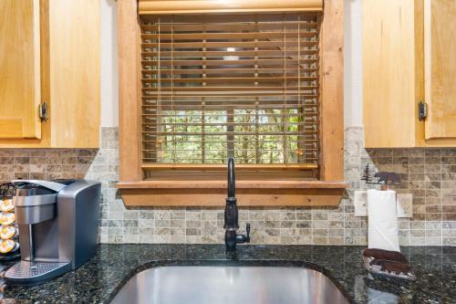 a kitchen counter with a sink and a window at Baldknobber Ridge Escape - West Branson Cabin in Branson West