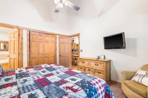 a bedroom with a bed and a tv on the wall at Baldknobber Ridge Escape - West Branson Cabin in Branson West