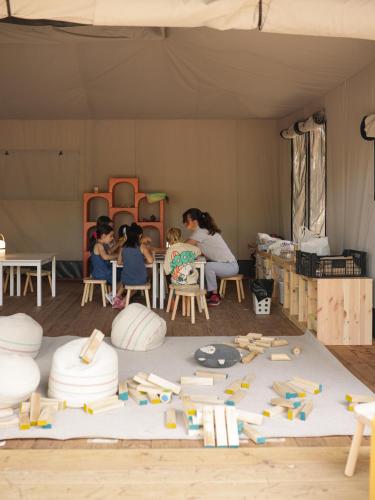a group of children sitting in a room with toys at wecamp Santa Cristina in Santa Cristina d'Aro