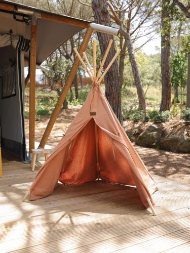 a tent sitting on the ground next to a tree at wecamp Santa Cristina in Santa Cristina d'Aro
